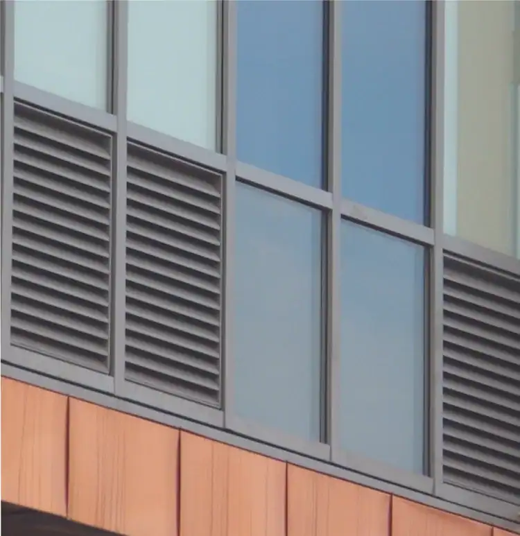 Louvre backing panels installed beneath glazed window sections on a building facade